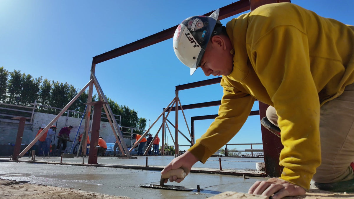 Construction crew member finishing a concrete slab