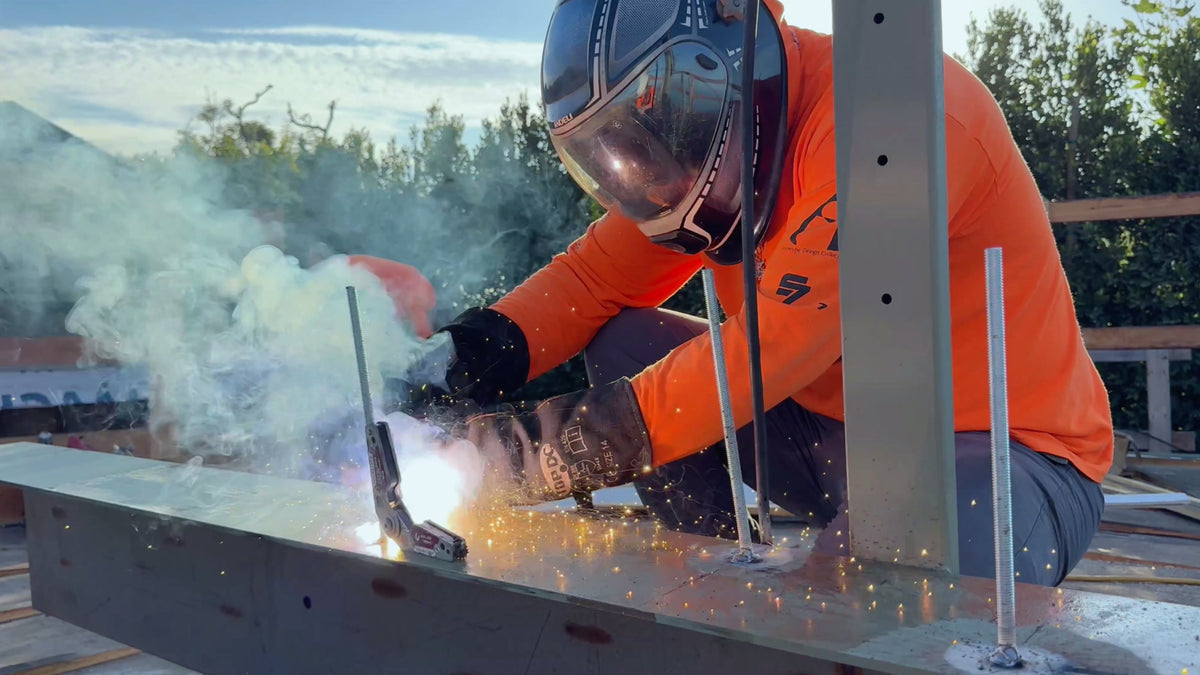 Worker welding a steel connection at a construction site
