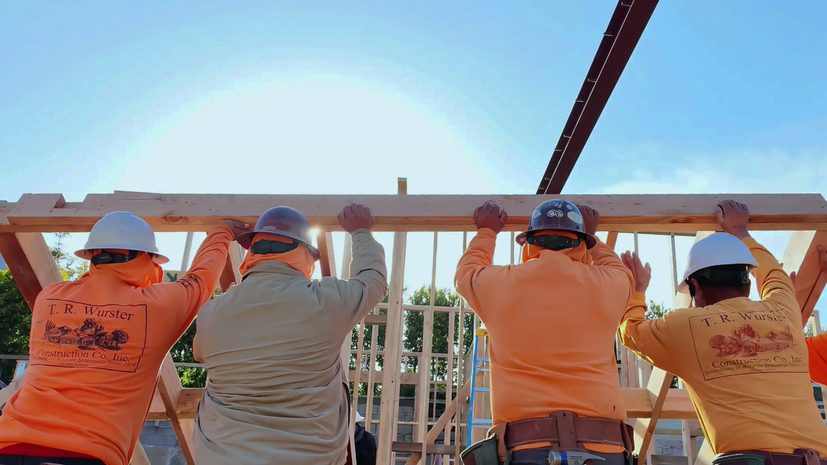 Construction crew raising timber framing at a jobsite